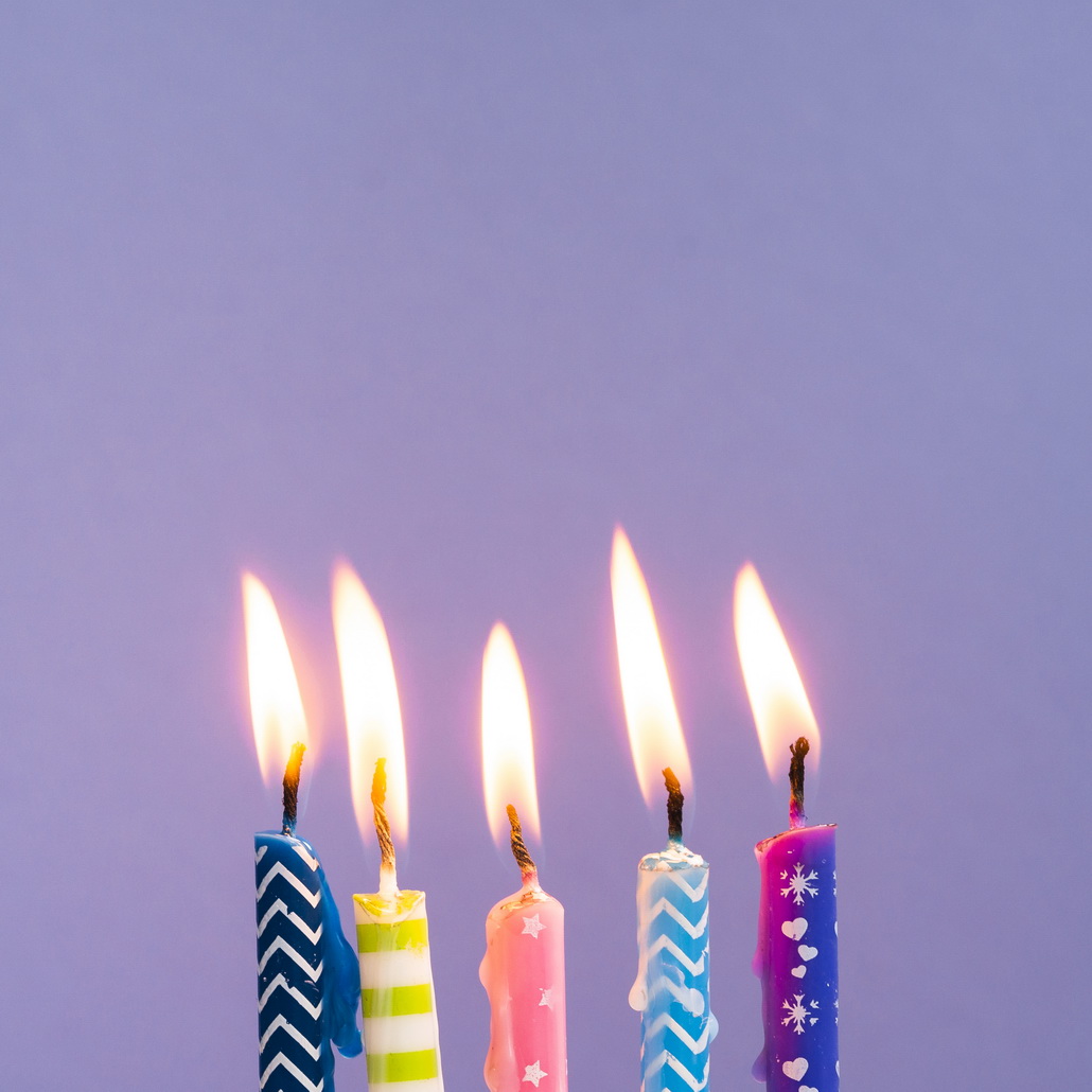 close-up-colorful-candles-on-purple-background
